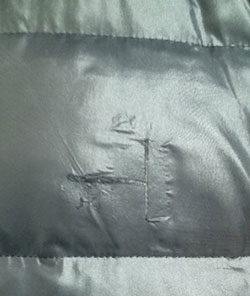 図6. ダウンジャケットの引裂き事故例(粘着テープで補修済み)